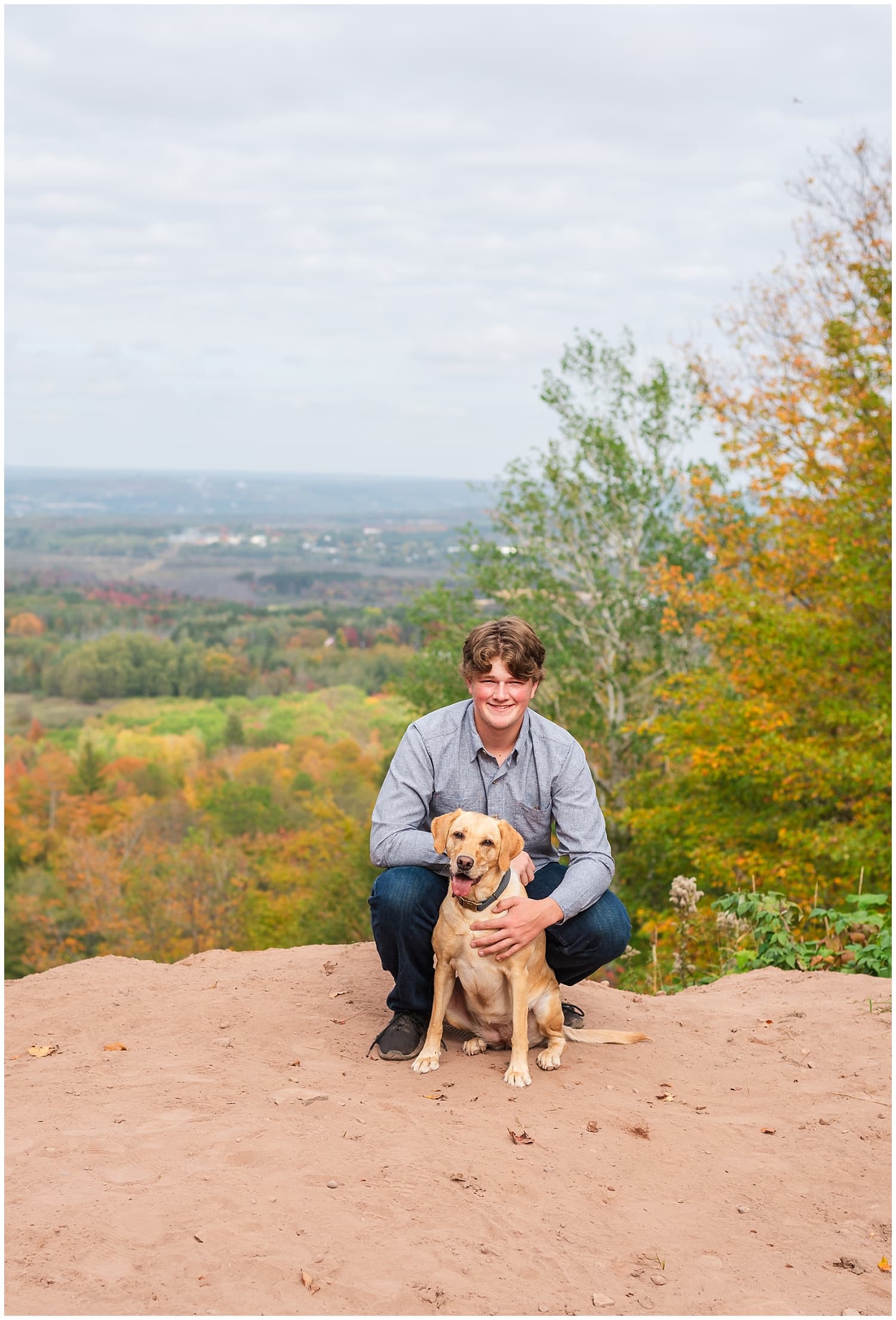 high school senior boy with his dog at whealkate bluff in south range michigan upper peninsula