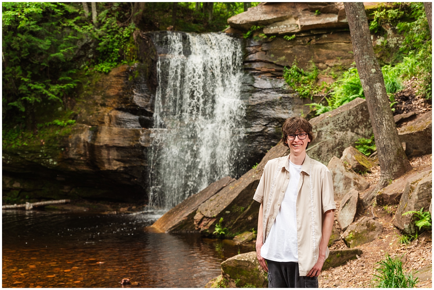 boy laughs in front of popular keweenaw waterfall middle hungarian falls for senior pictures