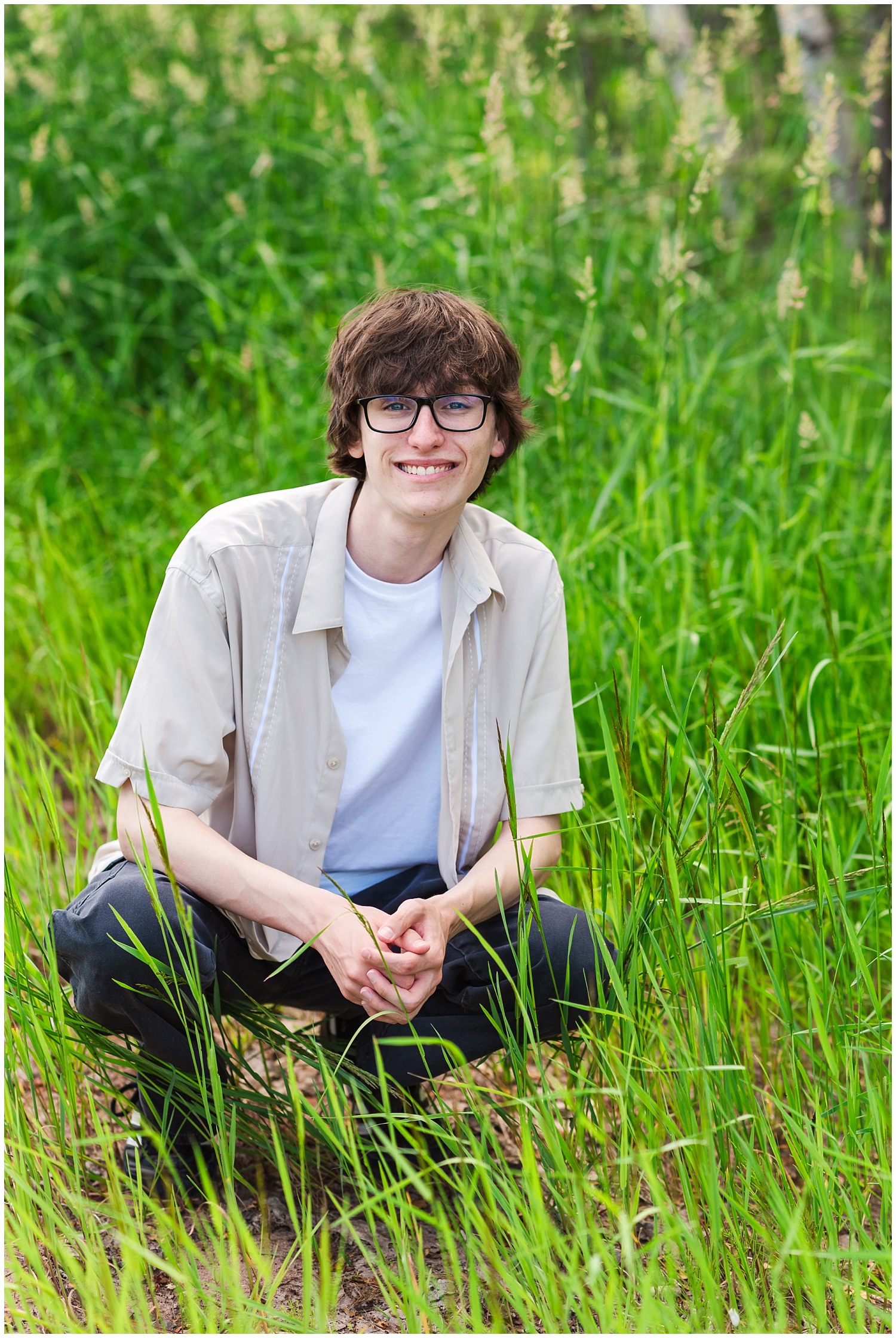 high school senior boy in tall green grass