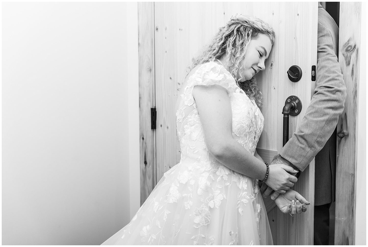 bride leans on door during first touch before wedding ceremony