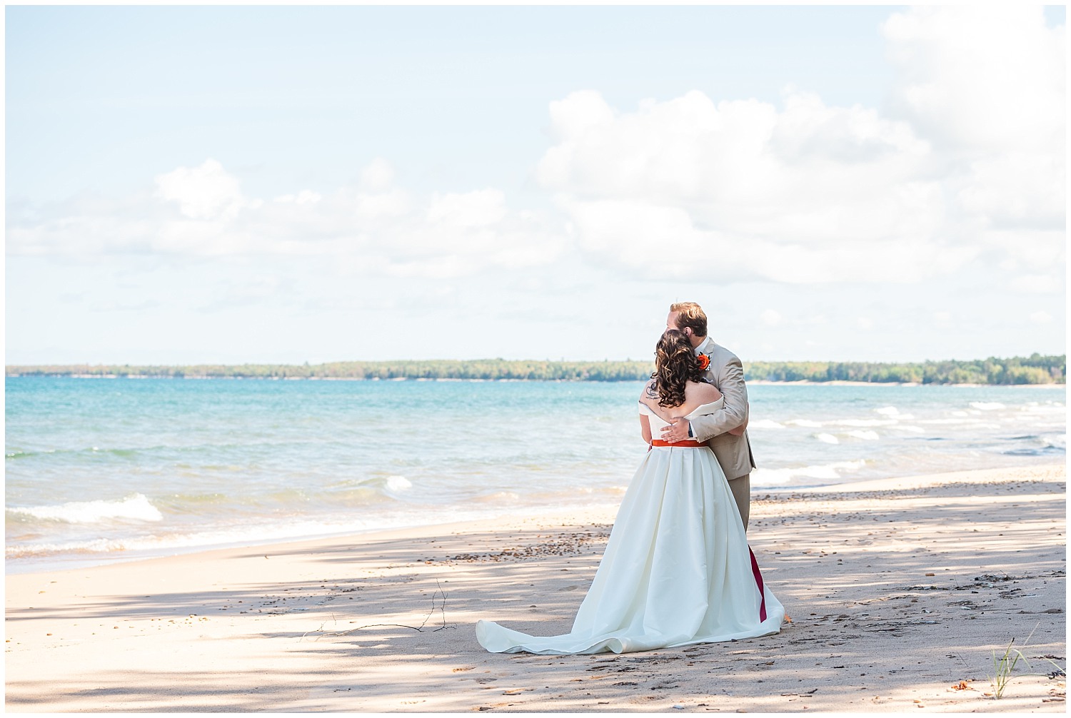 bride and groom enjoy view near lake superior on the beach marquette michigan