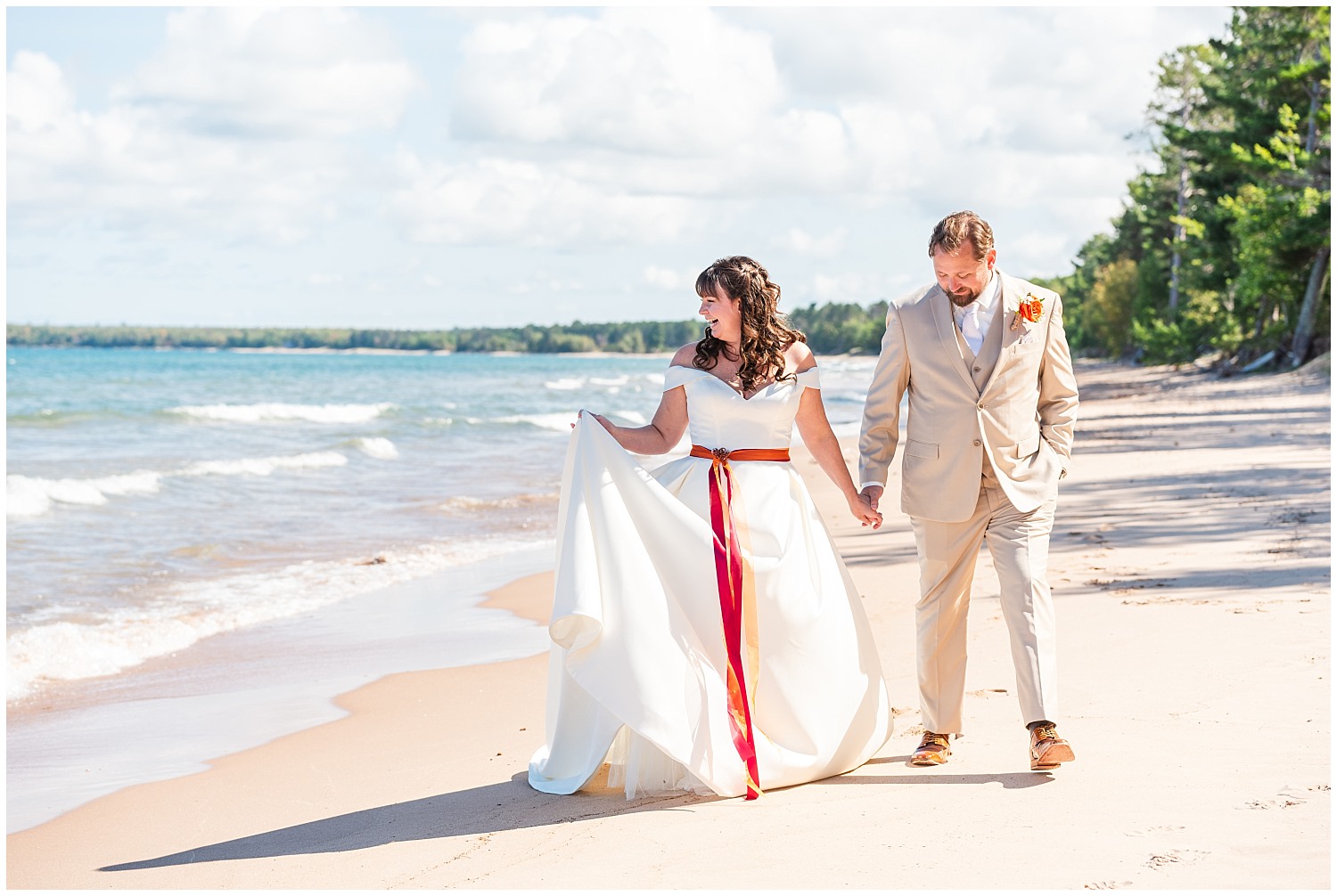wedding portraits bride and groom on beach of lake superior in marquette mi upper peninsula